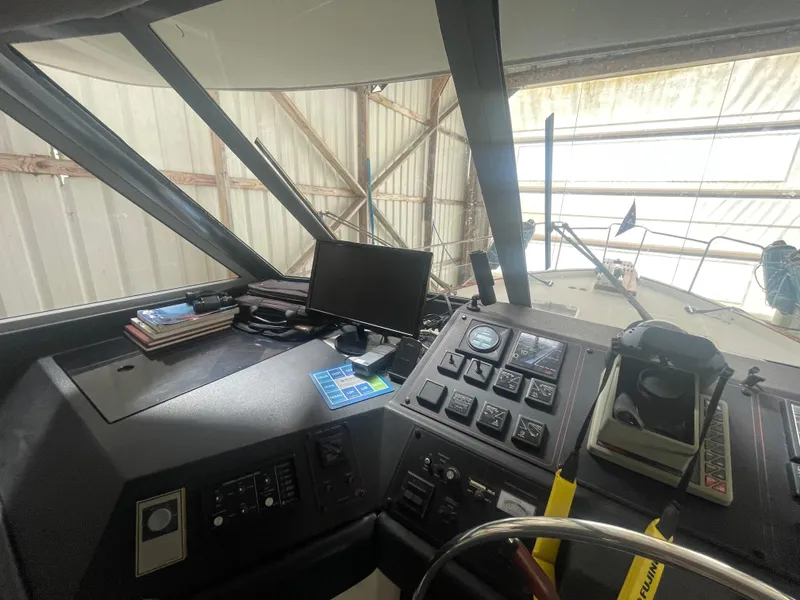 Slide: The Image of 1988 Bayliner 4588 helm with navigation controls and instruments in a covered dock. - 39