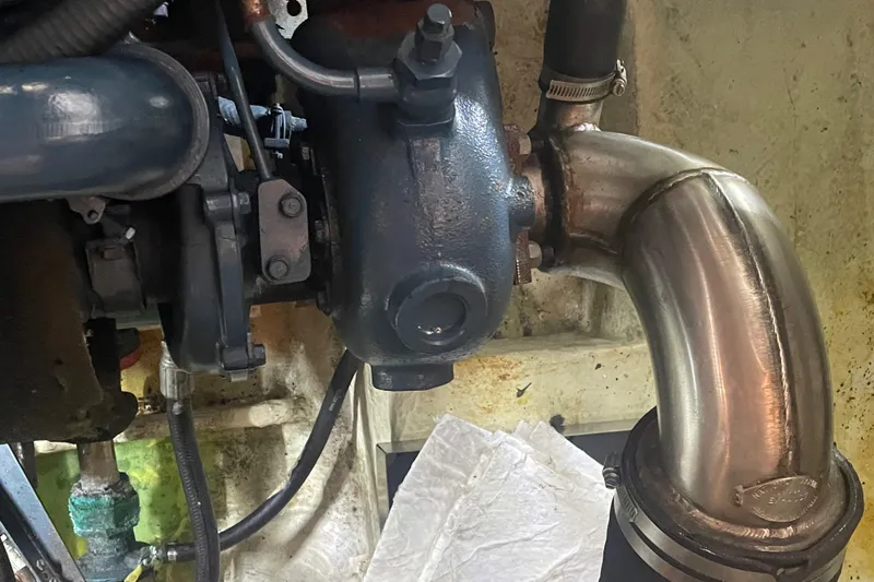 Slide: The Image of Engine component of a 1988 Bayliner 4588 boat, featuring metal pipes and connections. - 40