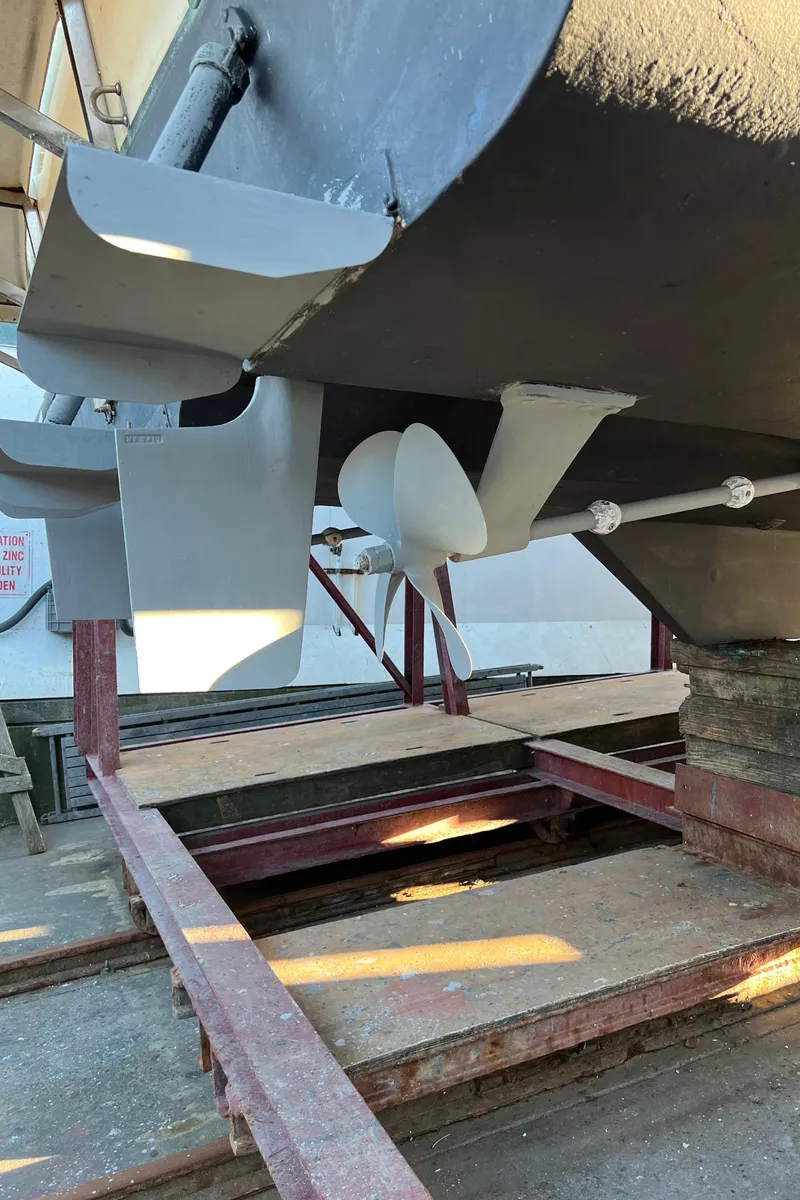 Slide: The Image of 1988 Bayliner 4588 yacht underside showing propeller and rudder in dry dock. - 41