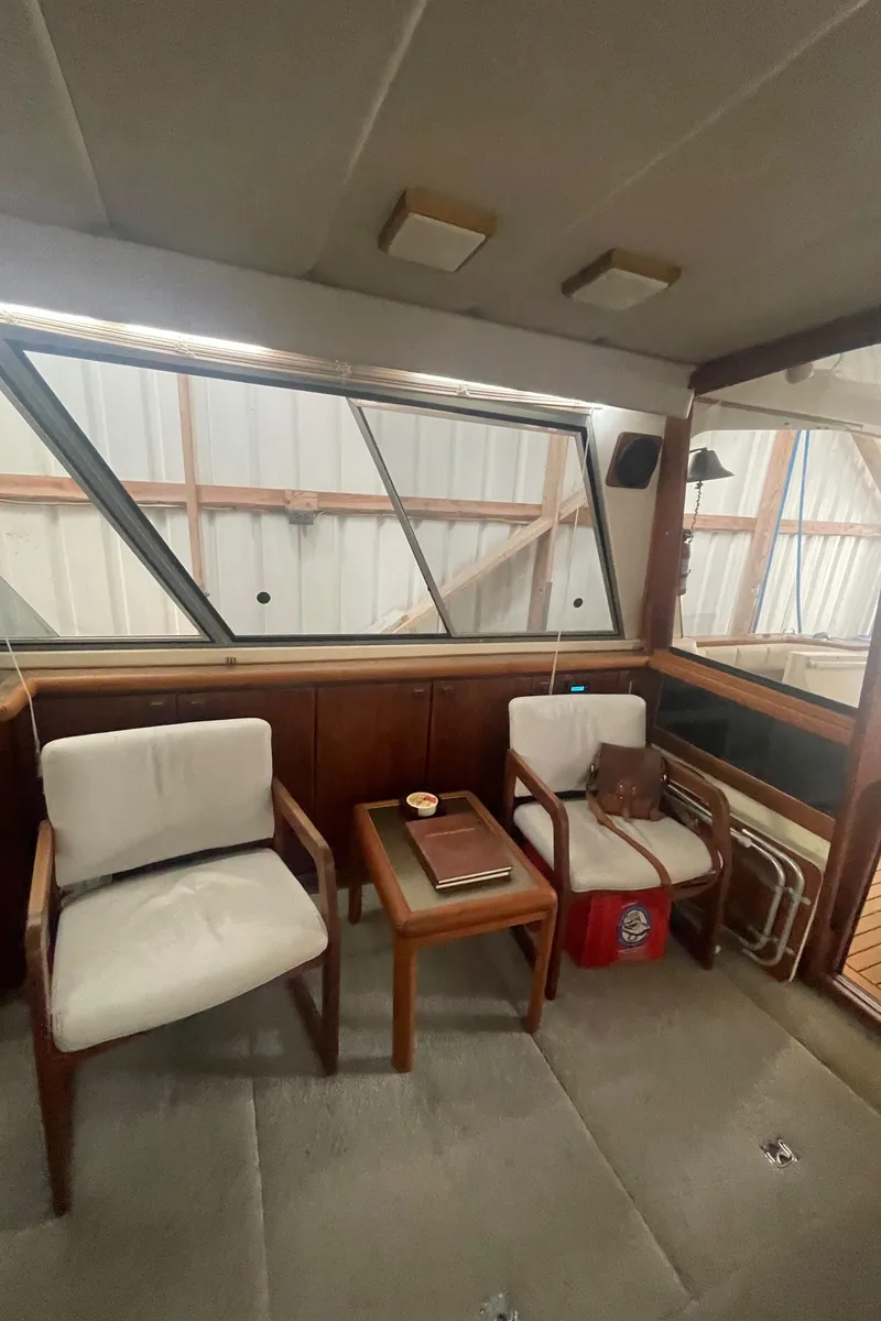 Slide: The Image of Interior of 1988 Bayliner 4588 yacht with chairs and table, showcasing classic design. - 6