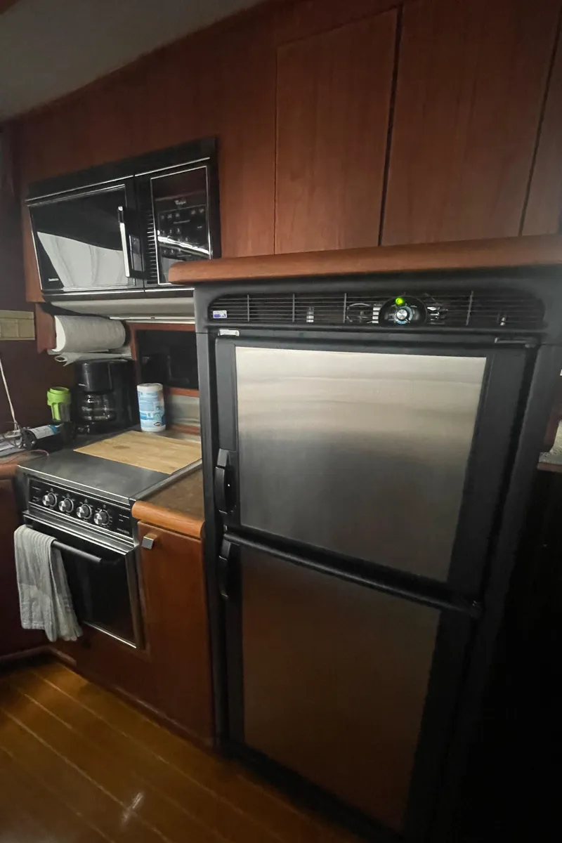 Slide: The Image of 1988 Bayliner 4588 yacht kitchen with stainless steel appliances and wooden cabinetry. - 9