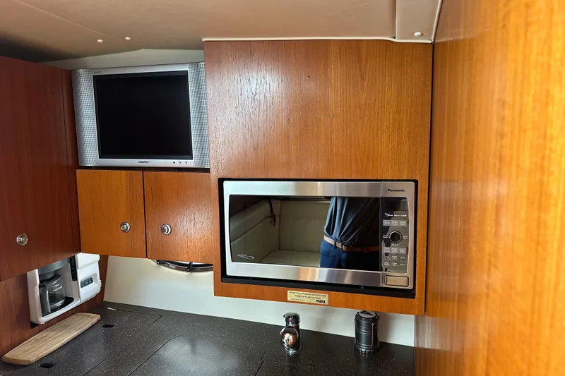 Slide: The Image of 2005 Tiara Yachts 3800 Open interior with microwave and TV in wooden cabinetry. - 8