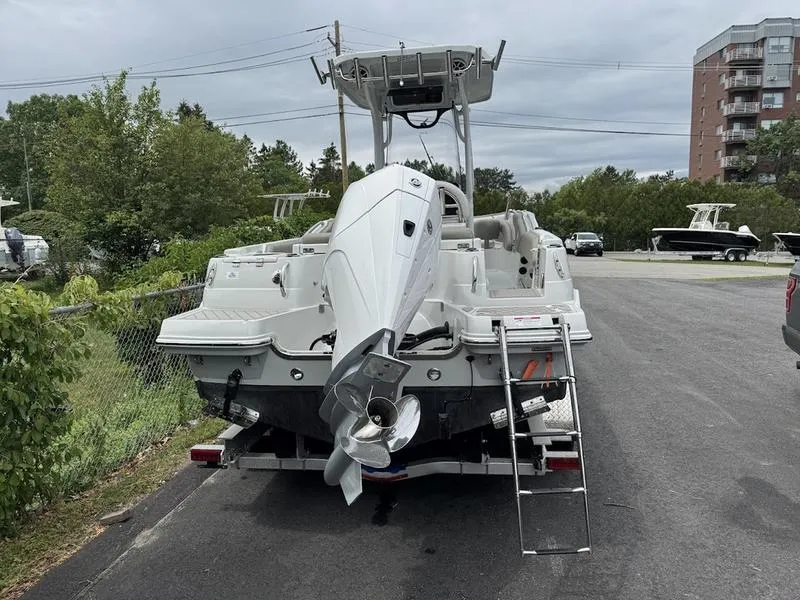 Slide: The Image of 2024 Finseeker 230 CC boat with outboard motor, parked on a trailer in a lot. - 2