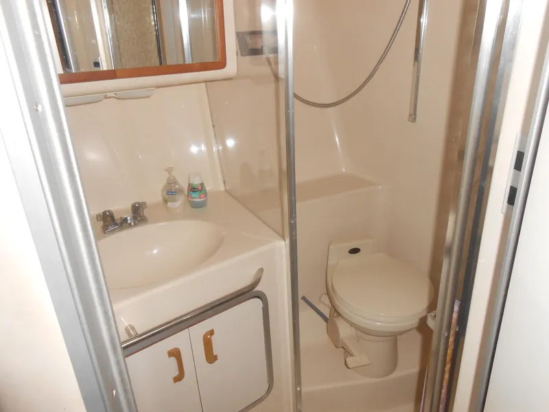 Slide: The Image of Bathroom interior of 1990 Sea Ray 350 Sundancer Coupe with sink and toilet. - 9