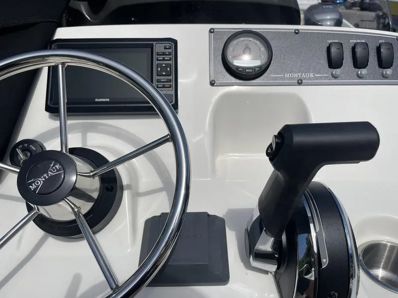 Slide: The Image of 2024 Boston Whaler 150 Montauk dashboard with steering wheel and controls. - 6