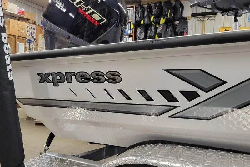 Slide: The Image of 2025 Xpress H20C Crappie boat in showroom, featuring sleek design and Yamaha VMAX engine. - 20