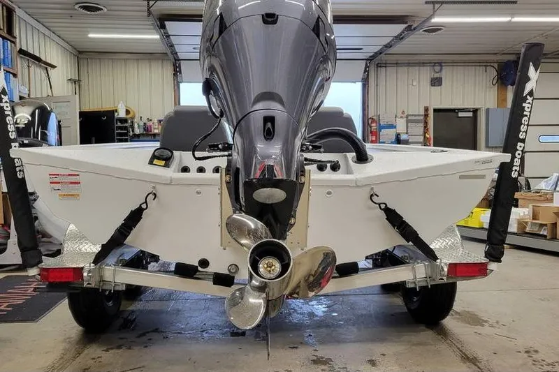 Slide: The Image of 2025 Xpress H20C Crappie boat in garage, rear view with motor and propeller. - 22