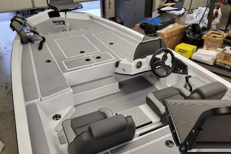 Slide: The Image of 2025 Xpress H20C Crappie boat interior with steering wheel and seating in a garage setting. - 24
