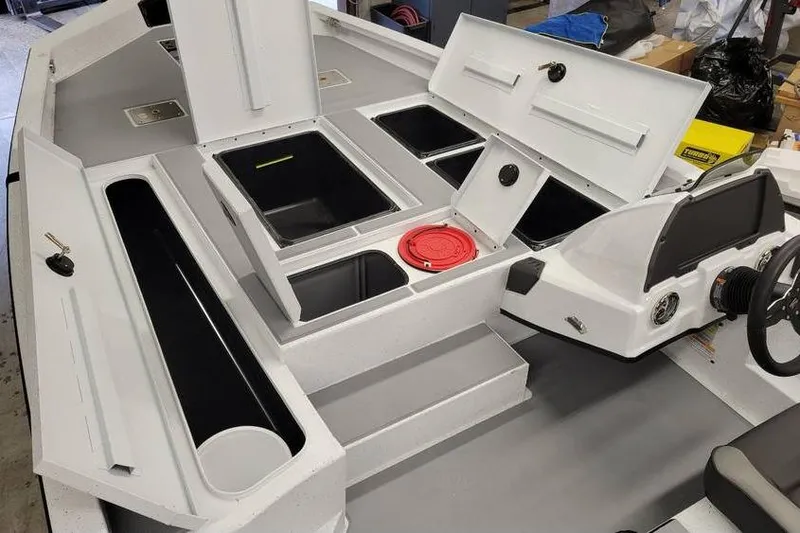 Slide: The Image of 2025 Xpress H20C Crappie boat interior with storage compartments and steering console. - 26