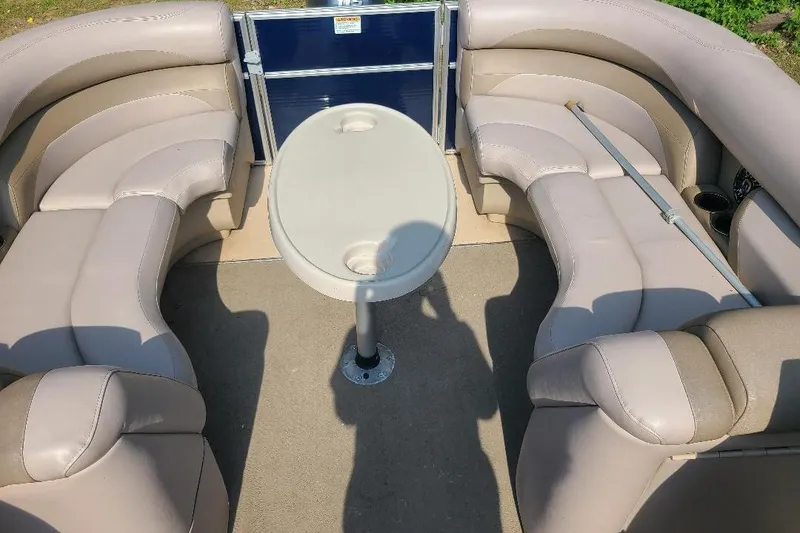 Slide: The Image of 2013 Starcraft Limited 236 Starlounger boat interior with beige seating and central table. - 4