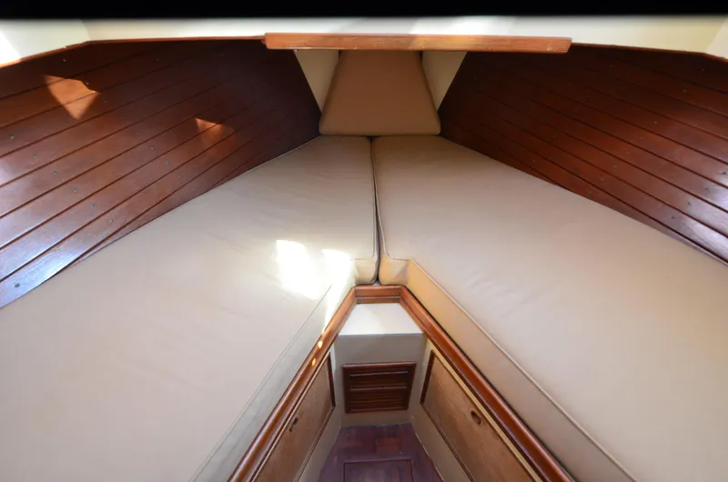 Slide: The Image of 1977 Grand Banks GB 32 cabin interior with wooden paneling and beige cushions. - 10