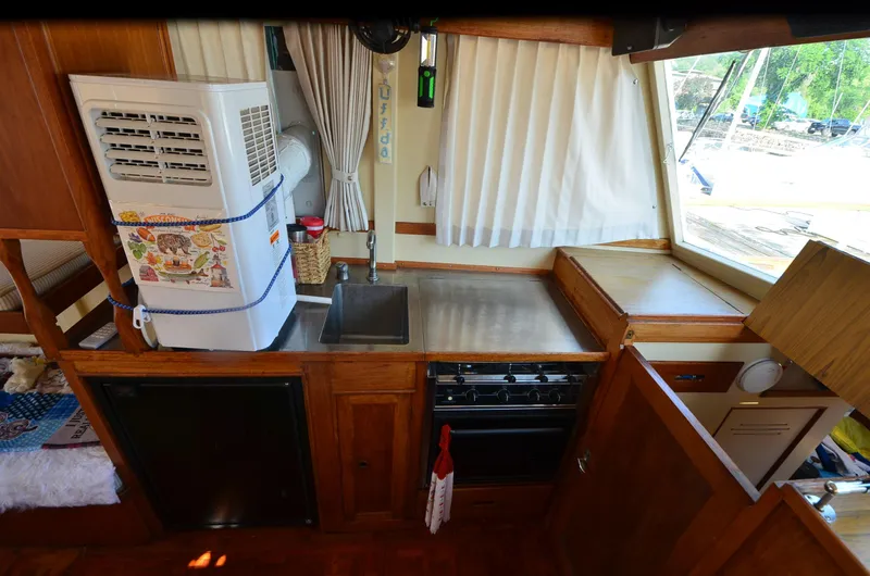 Slide: The Image of 1977 Grand Banks GB 32 boat interior with kitchen, sink, stove, and air conditioner. - 17