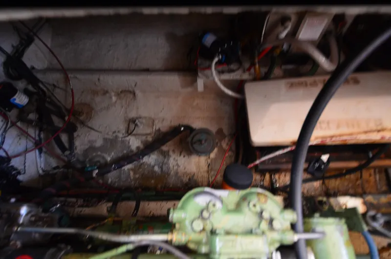 Slide: The Image of Engine room of a 1977 Grand Banks GB 32 boat, showing mechanical components and wiring. - 26