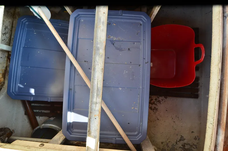 Slide: The Image of Storage area with blue bins and red container on a 1977 Grand Banks GB 32 boat. - 27