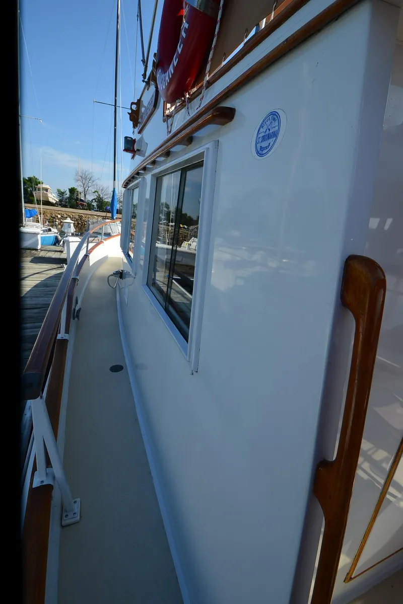 Slide: The Image of 1977 Grand Banks GB 32 yacht side view, docked under clear blue sky. - 29