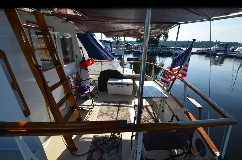Slide: The Image of 1977 Grand Banks GB 32 yacht deck with American flag, docked at marina. - 3