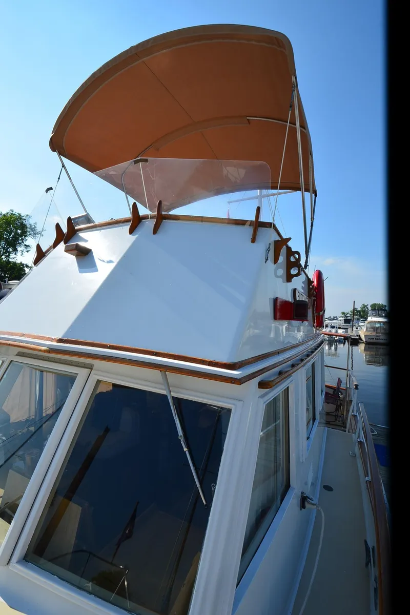 Slide: The Image of 1977 Grand Banks GB 32 boat with tan canopy, docked at marina. - 33