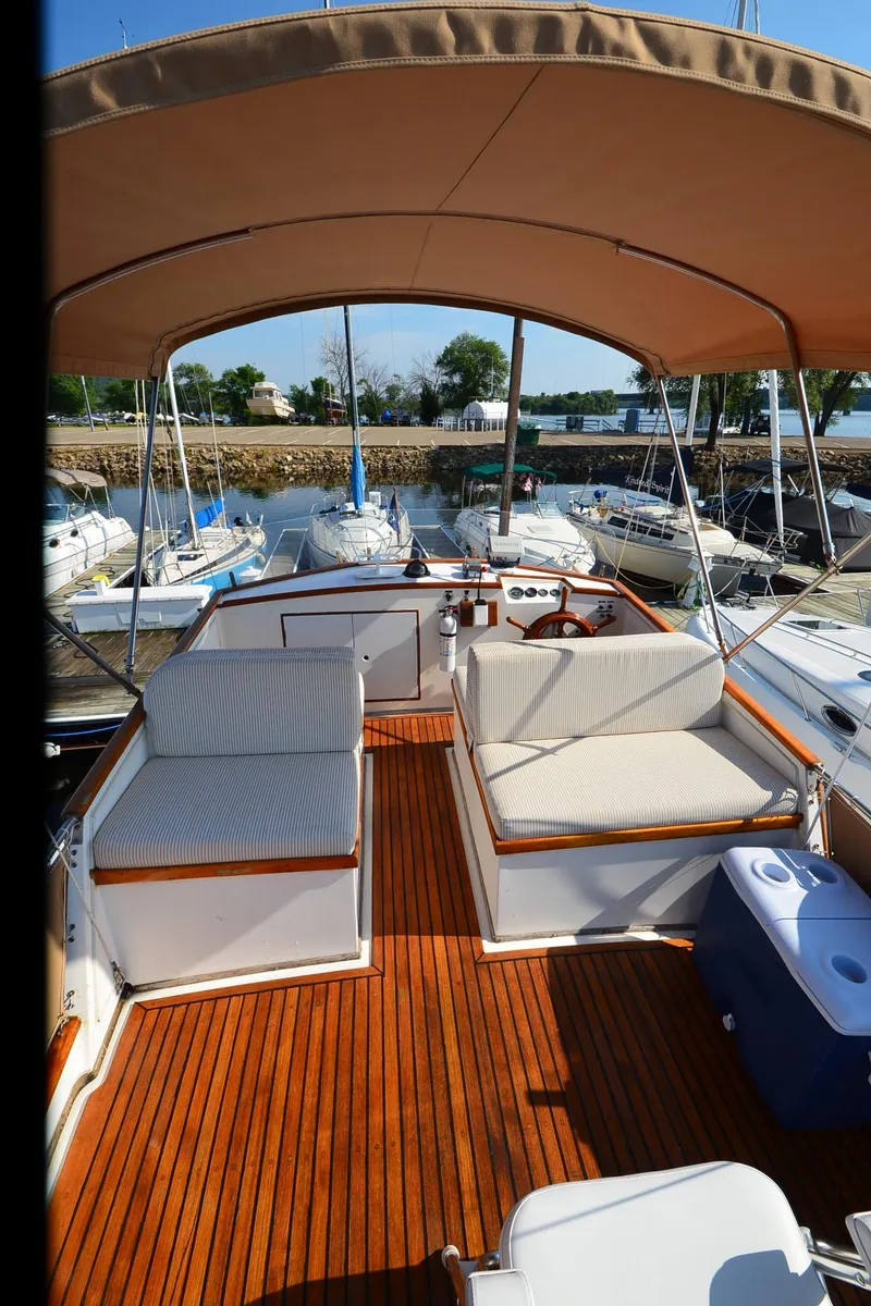 Slide: The Image of 1977 Grand Banks GB 32 yacht deck with seating and canopy, docked at marina. - 34