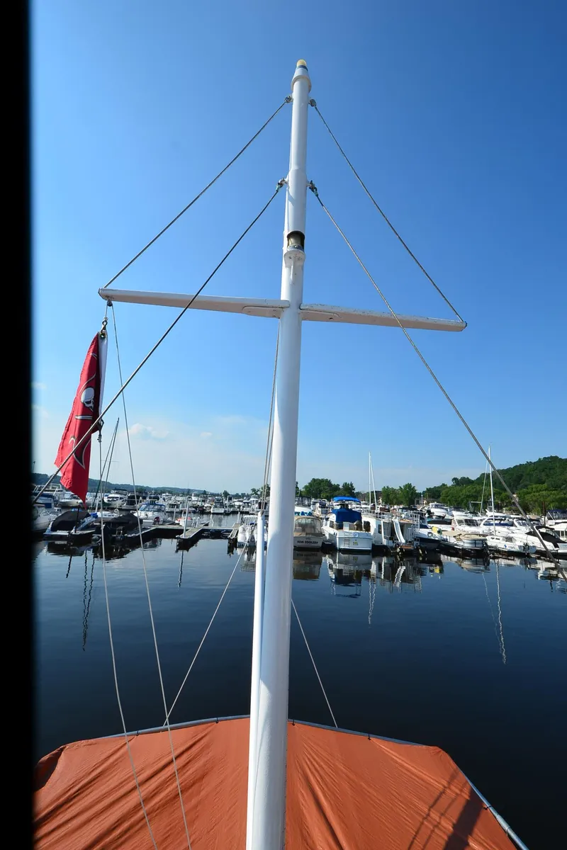Slide: The Image of 1977 Grand Banks GB 32 boat mast at marina, clear blue sky, calm water. - 36