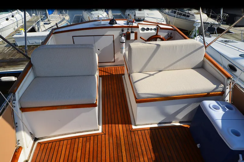 Slide: The Image of 1977 Grand Banks GB 32 boat deck with cushioned seating and wooden flooring. - 5