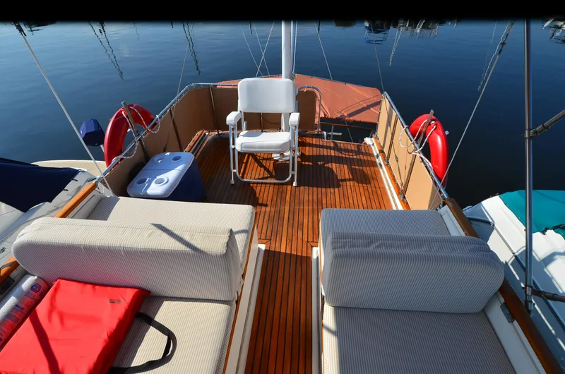 Slide: The Image of 1977 Grand Banks GB 32 boat deck with seating, cooler, and life rings. - 8