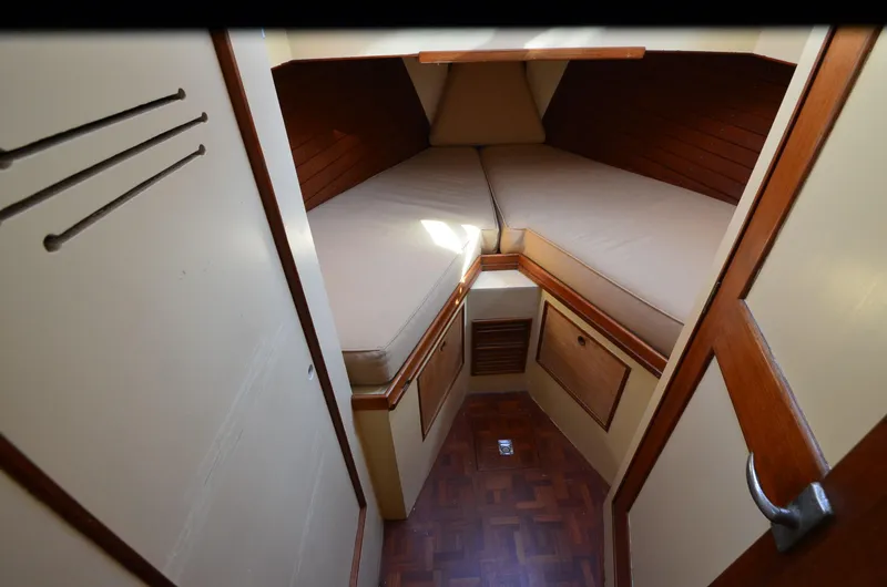 Slide: The Image of 1977 Grand Banks GB 32 cabin interior with V-berth and wooden accents. - 9