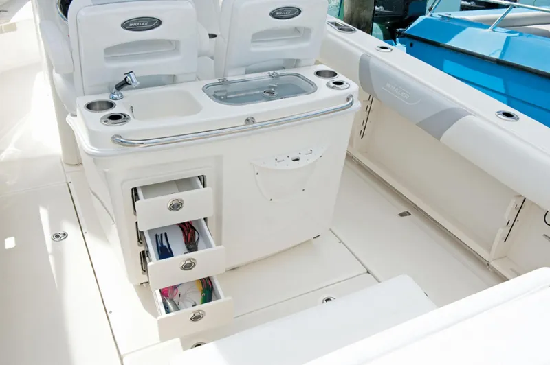 Slide: The Image of 2014 Boston Whaler 250 Outrage boat interior with storage drawers and sink. - 15