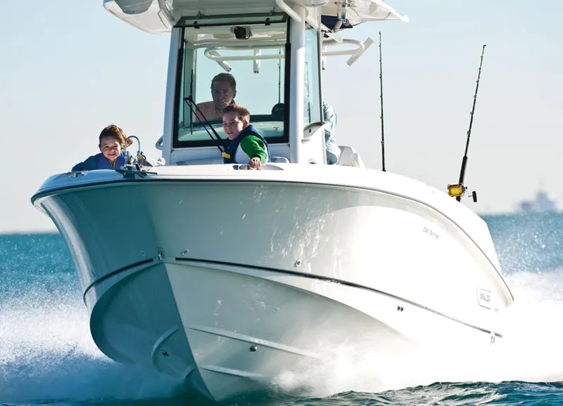 Slide: The Image of 2014 Boston Whaler 250 Outrage boat cruising with passengers on a sunny day. - 26