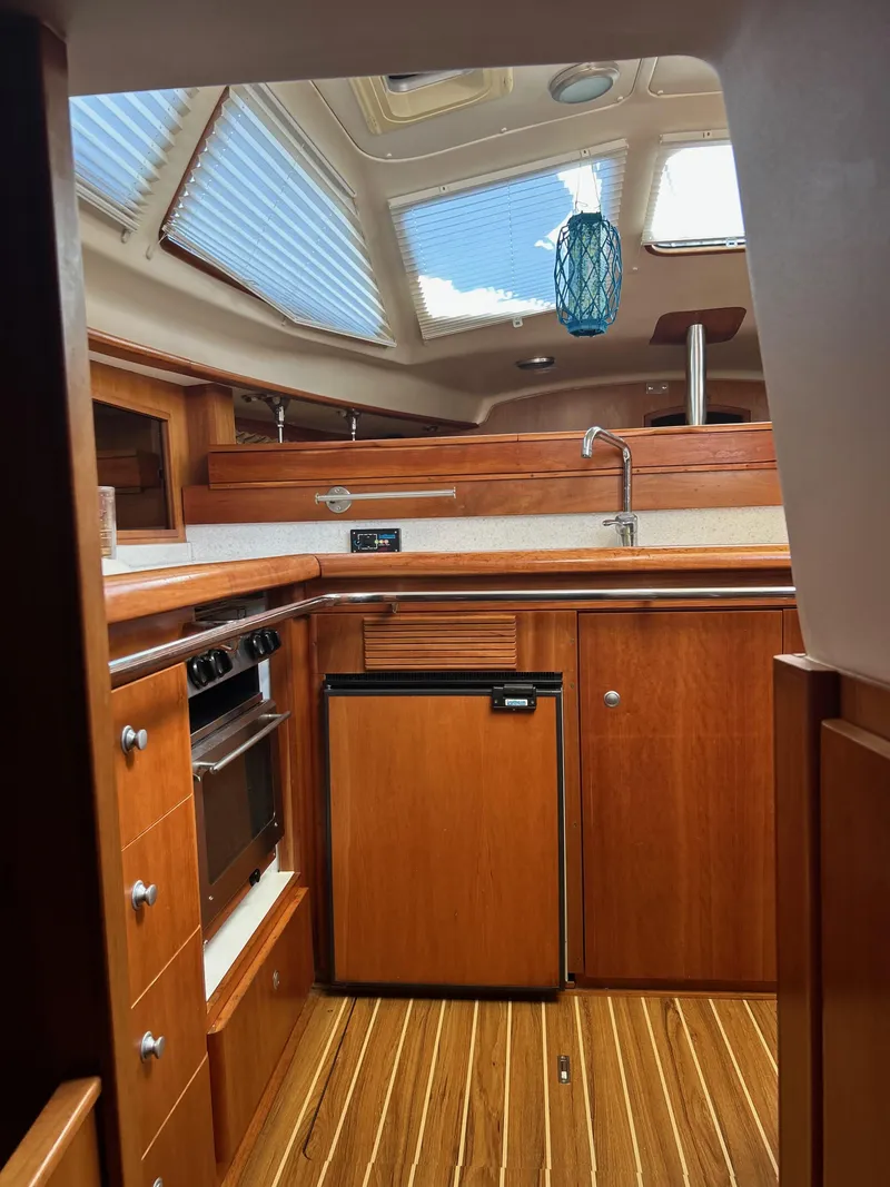 Slide: The Image of Interior of 2006 Southerly 115 Mk IV yacht, featuring a compact wooden kitchen area. - 20