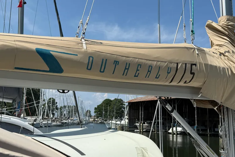 Slide: The Image of Sailboat boom with "Southerly 115" branding, docked in a marina, 2006 model. - 27