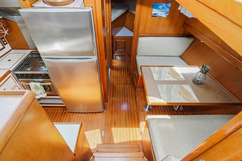 Slide: The Image of 1986 Offshore Yachts 48 Yachtfisher interior with kitchen, dining area, and wood finish. - 14