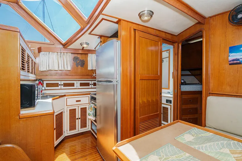 Slide: The Image of 1986 Offshore Yachts 48 Yachtfisher interior with wood finish, skylight, and modern kitchen amenities. - 16
