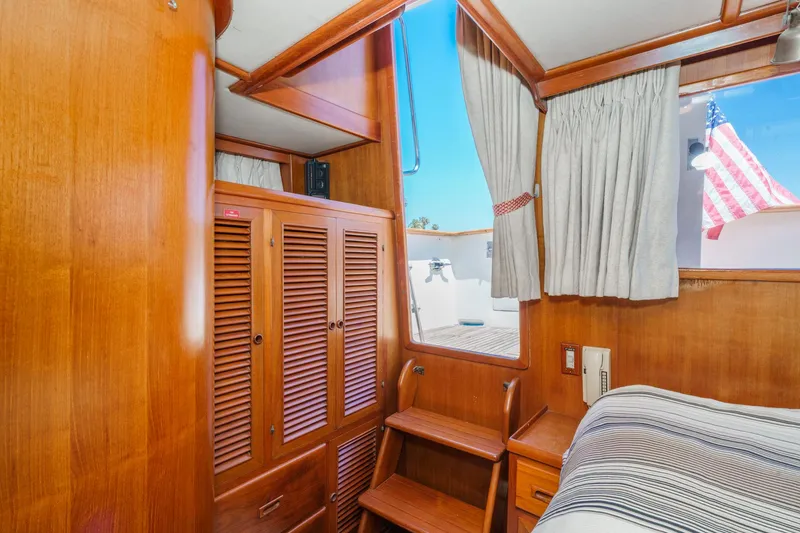 Slide: The Image of 1986 Offshore Yachts 48 Yachtfisher cabin interior with wooden finishes and window view. - 22