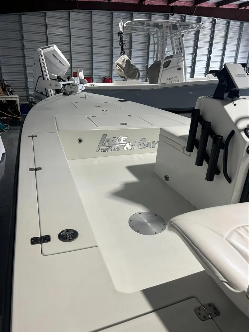 Slide: The Image of 2008 Lake & Bay Boca Grande boat in a storage facility, showcasing deck and seating area. - 23