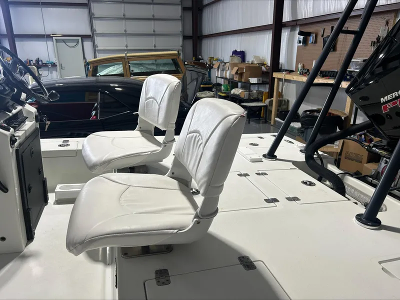 Slide: The Image of 2008 Lake & Bay Boca Grande boat interior with white seats in a garage setting. - 24