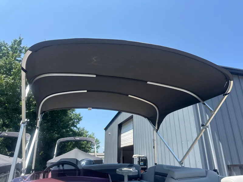 Slide: The Image of 2023 Bennington 22SX SWINGBACK boat with canopy, outdoor setting, clear sky. - 17