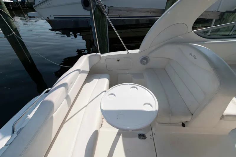 Slide: The Image of 2005 Sea Ray 280 Sundancer boat interior with white seating and round table. - 10