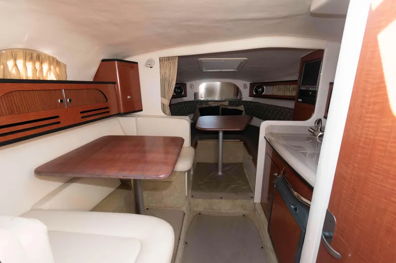 Slide: The Image of 2005 Sea Ray 280 Sundancer cabin interior with dining area and kitchenette. - 13