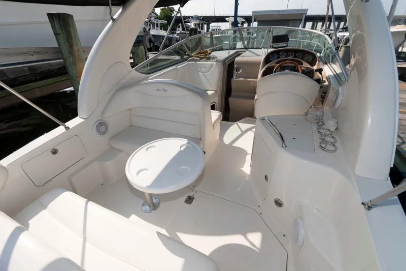 Slide: The Image of 2005 Sea Ray 280 Sundancer boat interior with seating and helm, docked at marina. - 5