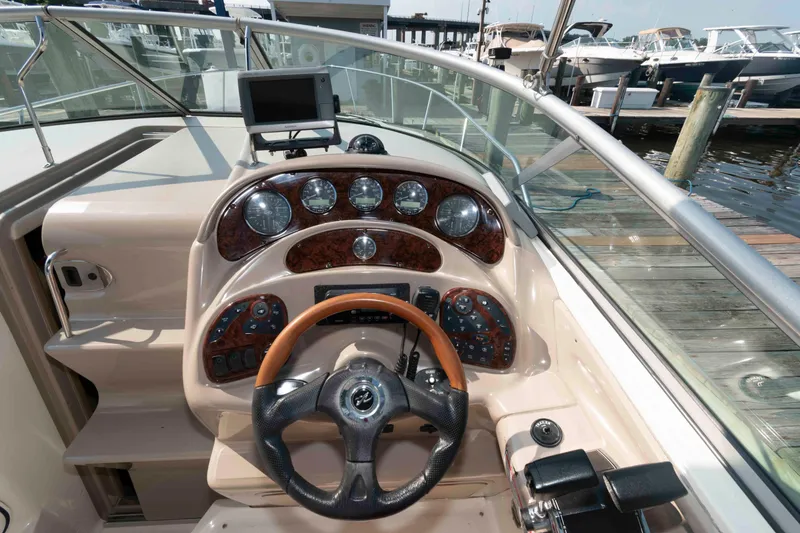 Slide: The Image of 2005 Sea Ray 280 Sundancer helm with gauges, steering wheel, and navigation equipment. - 8