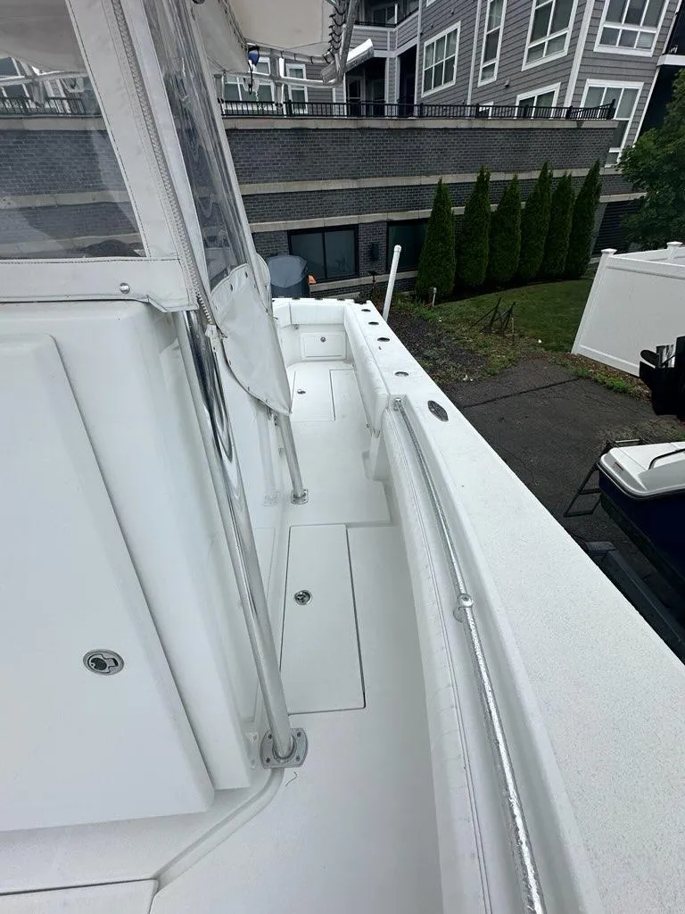 Slide: The Image of 2012 Onslow Bay 27 OE boat deck with white finish, docked near residential buildings. - 10