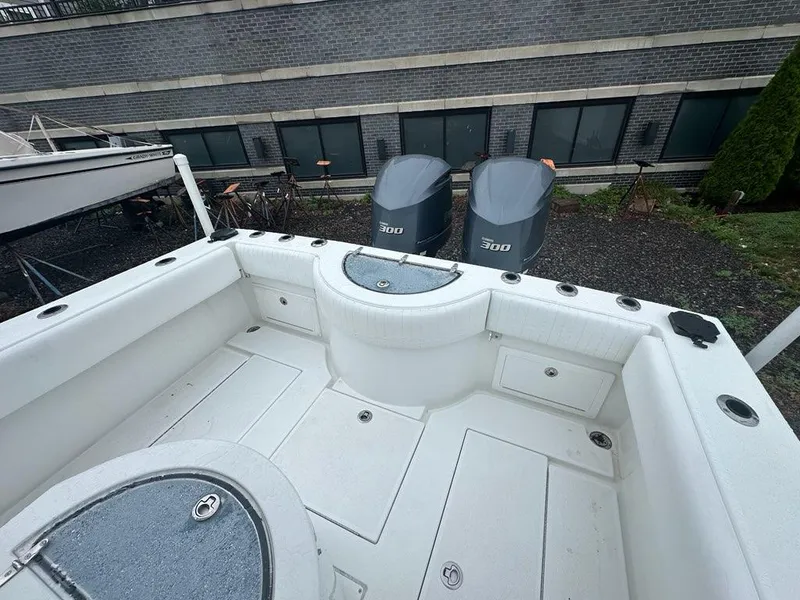 Slide: The Image of 2012 Onslow Bay 27 OE boat with twin 300 engines, docked near a brick building. - 15