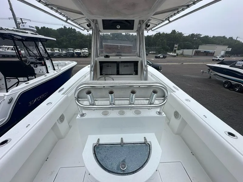 Slide: The Image of 2012 Onslow Bay 27 OE boat interior with rod holders and livewell, parked at a dealership. - 16