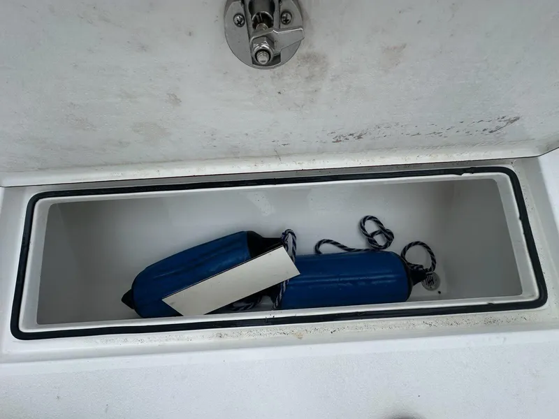 Slide: The Image of Storage compartment on a 2012 Onslow Bay 27 OE boat with blue fenders inside. - 21