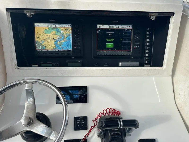 Slide: The Image of 2012 Onslow Bay 27 OE boat dashboard with navigation screens and steering wheel. - 5