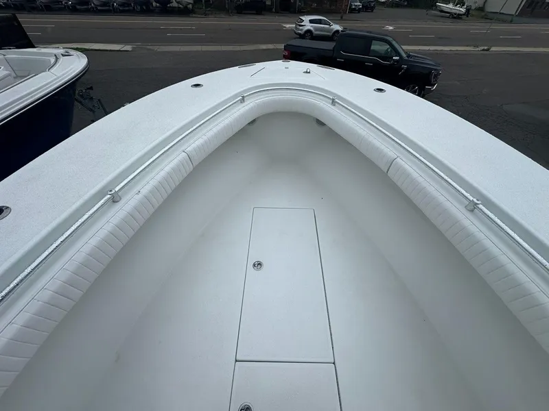 Slide: The Image of 2012 Onslow Bay 27 OE boat interior with white seating and storage compartment. - 6