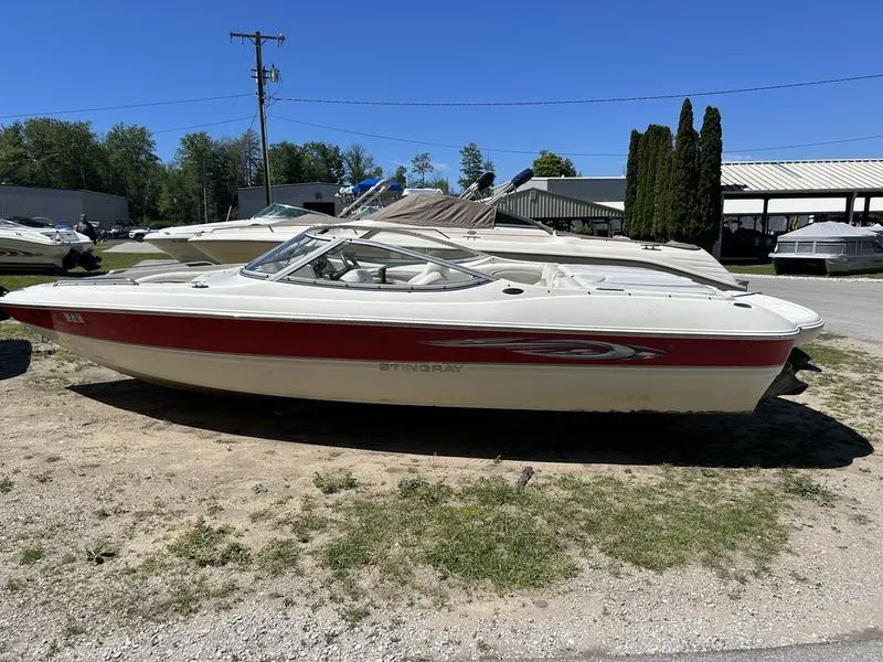 The Image of 2007 Stingray 210LR boat with red stripe, parked outdoors on a sunny day. - 1