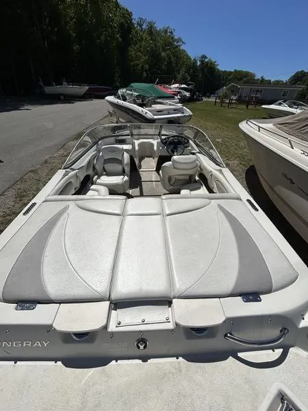 Slide: The Image of 2007 Stingray 210LR boat with white interior, parked outdoors under clear blue sky. - 12