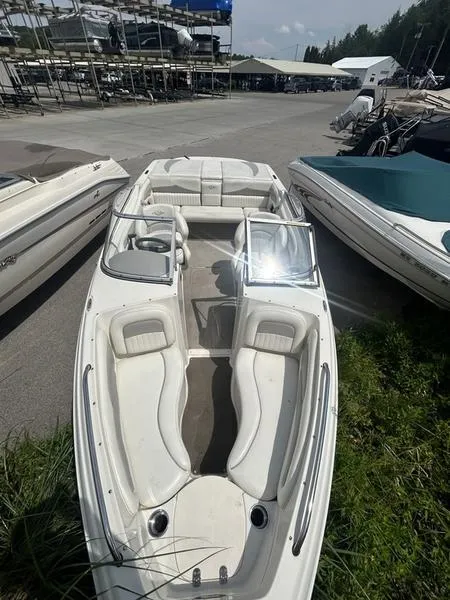Slide: The Image of 2007 Stingray 210LR boat with white interior, docked outdoors on a sunny day. - 4