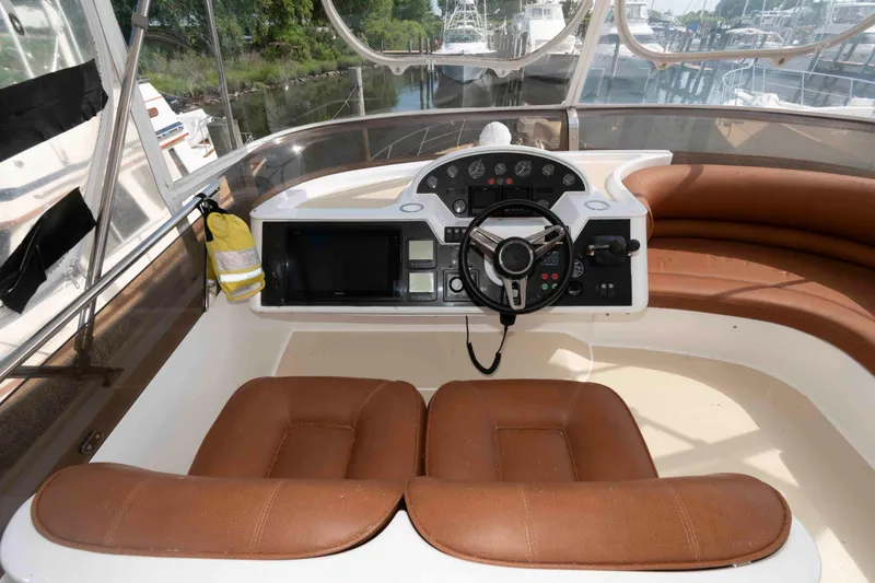 Slide: The Image of Helm of 2003 Princess 50 yacht with brown seating and modern controls. - 10